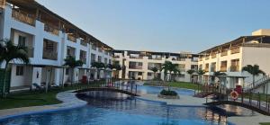 a hotel with a bridge over a pool with buildings at Condomínio Boas Vistas - 31 A in Aracati