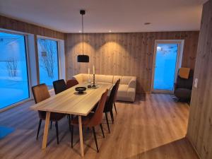 a dining room with a table and a couch at Lofoten Seaview apartment in Vestvågøya