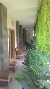 a hallway with benches and plants in a building at Kubu Carik in Legian