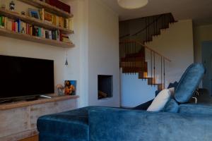 a person laying on a blue couch in a living room at Pane e Marmellata in Signa