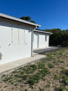 un edificio blanco con dos ventanas laterales en Locations Villa Saint-Francois, en Saint-François