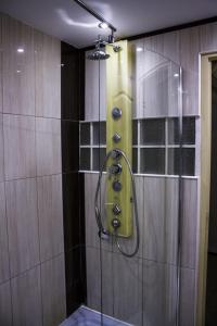 a shower with a glass door in a bathroom at Travel Inn Apartments in Budapest