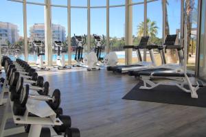 une salle de sport avec une rangée de tapis de course et de machines dans l'établissement 5-Star Complex With 3 Pools & Gym, à Orihuela Costa