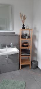 une salle de bain avec un lavabo et une étagère avec des serviettes dans l'établissement Servus & Moin - Bei uns Daheim!, à Meißendorf 30 autres photos