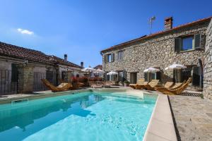 a swimming pool in front of a stone house at Albergo del Bramante in Roccaverano