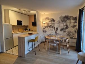 a kitchen and dining room with a table and chairs at Appartement cosy près du RER in Chessy