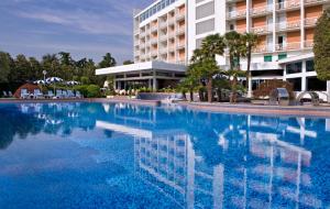 a large swimming pool in front of a hotel at Grand Hotel Terme & Spa in Montegrotto Terme