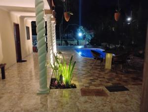 累西腓Refúgio Completo com Piscina em Aldeia dos Cãmaras的一个带柱子和椅子的房间和一个游泳池