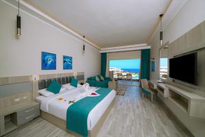 马萨阿拉姆SIRENA BEACH RESORT & SPA的配有一张大床和一台电视的酒店房间