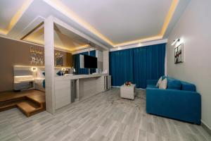 马萨阿拉姆SIRENA BEACH RESORT & SPA的客厅里有一张蓝色沙发和一台电视