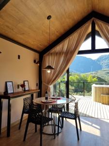a dining room with a table and chairs and a large window at Canastra Vibes in São Roque de Minas