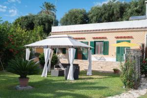 a white umbrella in a yard next to a house at Mammacaterina - Procida in Procida