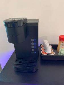 a black coffee maker sitting on a counter with cups at The Elegant Suite in Shared House in Cape Coral