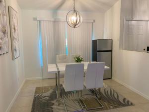 a dining room with a white table and white chairs at The Elegant Suite in Shared House in Cape Coral