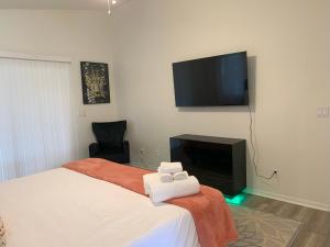 a bedroom with a bed and a flat screen tv at The Elegant Suite in Shared House in Cape Coral