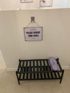 a black bench with a sign on a wall at The Elegant Suite in Shared House in Cape Coral
