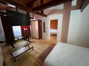 a bedroom with a bed and a flat screen tv at RED HOUSE Sinaia in Sinaia