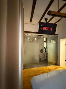 a room with a bed and a sign that reads netflix at MMA's Apartment - 1 min de Târgul de Crăciun Sibiu in Sibiu