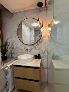 a bathroom with a sink and a mirror at MMA's Apartment - 1 min de Târgul de Crăciun Sibiu in Sibiu