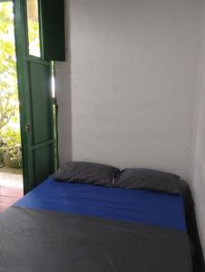 un letto in una stanza con porta verde di Koniminto Hostal a Pijao