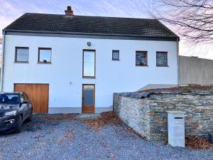 a white house with a brick wall at Les Pierris in La-Roche-en-Ardenne
