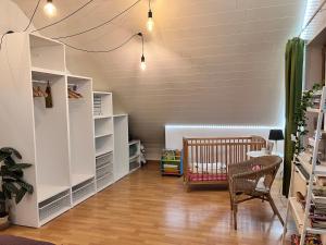 a baby room with a crib and a chair at Les Pierris in La-Roche-en-Ardenne