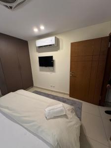 a bedroom with a white bed and a tv at Luxury condo with rooftop pool! in Islamabad +3 photos