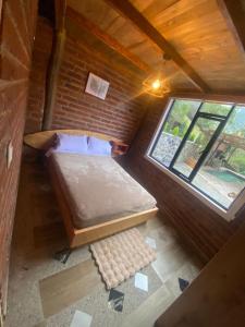 Postel nebo postele na pokoji v ubytování Cabañas El Guayabillo - Baños de agua Santa