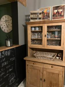 a large wooden cabinet with a clock on a wall at Les Pierris in La-Roche-en-Ardenne +69 photos