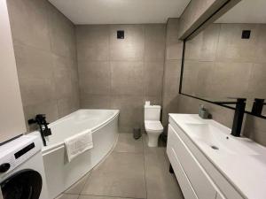 a bathroom with a tub and a toilet and a sink at Uzhhorod Apartment Lux in Uzhhorod