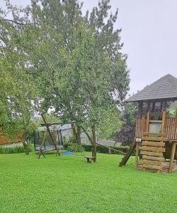 a playground with a tree and a swing set at Ferienwohnung Auer in Tulwitzdorf