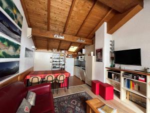 拉克吕萨Appartement au cœur du village pour 6 pers., terrasse, WiFi, parking, skis - FR-1-459-237的一间带红色桌子的客厅和一间厨房