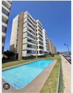 une piscine devant un grand bâtiment dans l'établissement Departamento La Serena 4 personas, à La Serena 2 autres photos