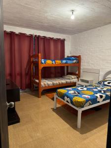 a room with two bunk beds and a tv at Casa en San Luis in La Floresta