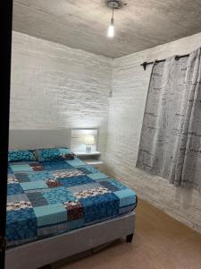 a bedroom with a bed and a white brick wall at Casa en San Luis in La Floresta
