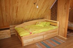 a small wooden bed in a wooden room at Atpūtas komplekss " Ezerkrasti" in Čornaja