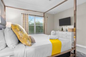 una camera da letto con un grande letto bianco e una televisione di Star Wars and Frozen, Pool, 10 min to Disney a Kissimmee Altre 33 foto