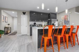 una cucina con sedie arancioni e bancone di Star Wars and Frozen, Pool, 10 min to Disney a Kissimmee