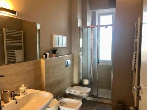 a bathroom with a sink and a toilet and a shower at Attico Ellen terrazza con vista in Turin +39 photos