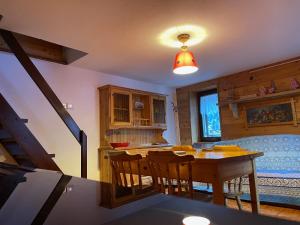 a kitchen and dining room with a table and a bed at La Maison del Bon Grato in Champorcher