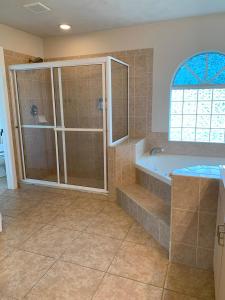 a bathroom with a shower and a tub and a sink at The Elegant Suite in Shared House in Cape Coral +37 photos