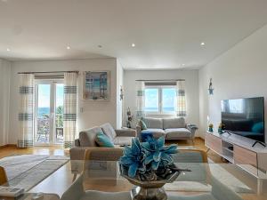 a living room with a couch and a tv at Vibing & Liming Ericeira in Ericeira