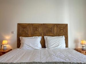 a bedroom with a large bed with white sheets and pillows at Vibing & Liming Ericeira in Ericeira