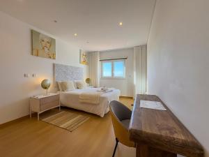 a bedroom with a bed and a table in it at Vibing & Liming Ericeira in Ericeira