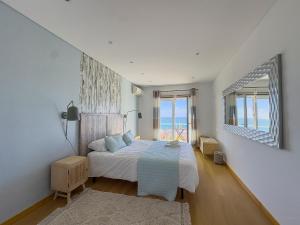 a bedroom with a bed and a view of the ocean at Vibing & Liming Ericeira in Ericeira