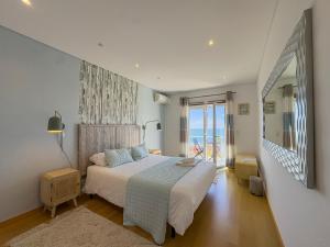 a bedroom with a bed with a view of the ocean at Vibing & Liming Ericeira in Ericeira
