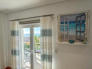 a room with a window with a view of the ocean at Vibing & Liming Ericeira in Ericeira