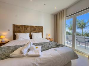 a bedroom with a large bed with towels on it at Vibing & Liming Ericeira in Ericeira