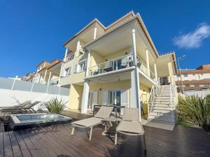 a house with two chairs and a table on a deck at Vibing & Liming Ericeira in Ericeira
