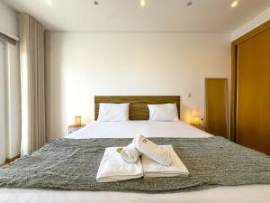 a bedroom with a bed with two towels on it at Vibing & Liming Ericeira in Ericeira